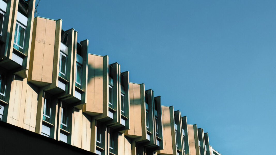 low-angle-shot-brown-building-with-windows-dark-blue-sky (1lllllllll)